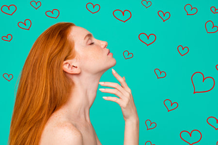 Profile side view portrait of red-haired girl with pure clear fresh smooth perfect skin, spa, therapy, treatment, copy-space, isolated on green turquoise backgroundの写真素材