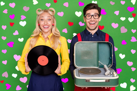 Photo of young excited couple music vintage vinyl player party audio isolated over green color...