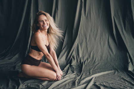 Full length no filter studio photo of shiny cute woman wear lingerie enjoying self acceptance isolated khaki cloth backgroundの写真素材