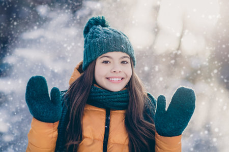 Photo of pretty cute schoolgirl wear windbreaker jacket rising hands arms enjoying snowfall weather...