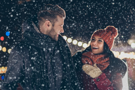 Photo of two people spend x-mas evening near newyear tree enjoy frosty weather and romance chatting wearing warm winter coats outdoorsの写真素材