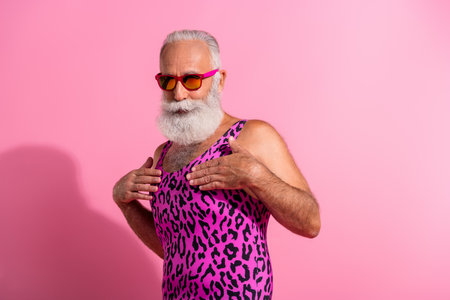 Photo of charismatic elderly cool man cover self wear leopard print overall isolated on pink color backgroundの写真素材