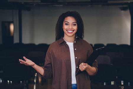 Portrait of young woman clipboard welcome invite business school training conference room indoorsの写真素材
