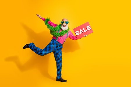 Full body photo of retired man dance plate boa dressed pink shirt vintage plaid pants fancy clothes isolated on yellow backgroundの写真素材