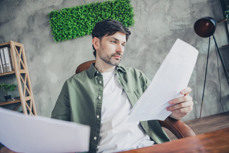 Young man working in a stylish office analyzes documents and paperwork