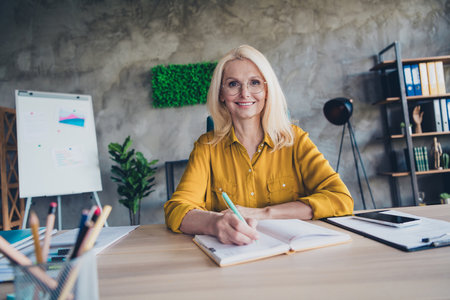 Photo of adorable positive lady broker wear shirt writing planner indoors workplace workshopの写真素材