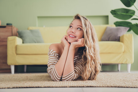 Young woman with blond hair relaxing indoors with happy smile during weekend at homeの写真素材