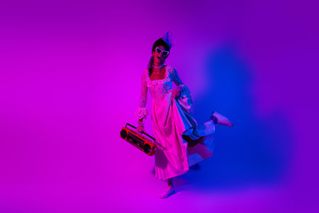 Beautiful young woman in elegant lace gown enjoying a vibrant masquerade partyの写真素材