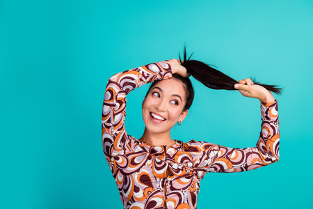 Photo portrait of attractive young woman pull hair look empty hair dressed stylish colorful clothes isolated on cyan color backgroundの写真素材