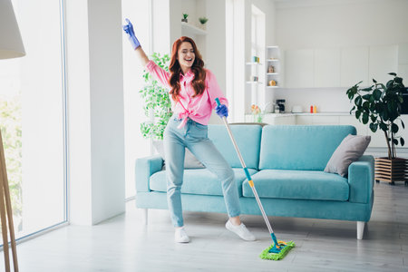 Full size photo of pretty young woman mop floor dancing modern bright interior apartment indoorsの写真素材