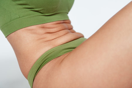 Cropped photo of mature lady stomach figure folds dressed khaki lingerie white background no filter...
