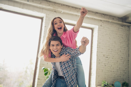 Two young friends enjoying cheerful moments together in a cozy home environment, expressing joy and positivityの写真素材