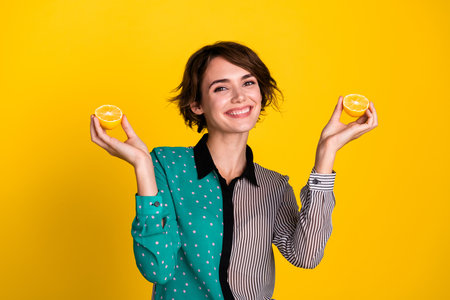 Photo of nice lovely adorable woman wear stylish clothes showing lemons isolated on yellow color...