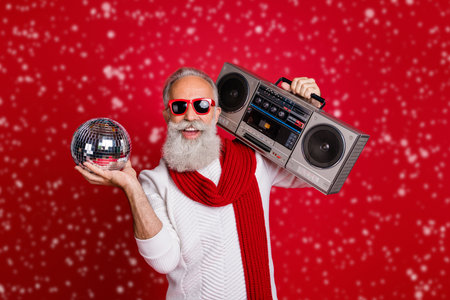 Portrait of his he nice cool handsome cheerful glad positive gray-haired man in pullover sweater having fun celebratory occasion nightclub disco isolated on bright vivid shine red backgroundの写真素材