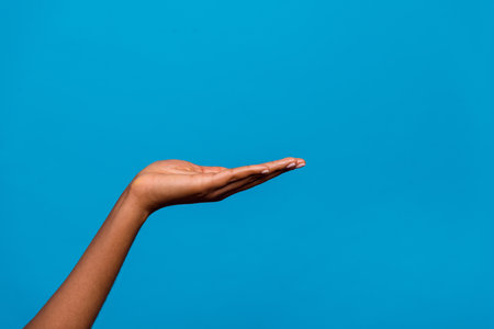 Cropped view of attractive girl hand holding on palm advert solution copy space isolated over bright blue color backgroundの写真素材