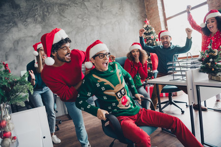 Photo of cheerful young people colleagues dressed new year ugly print clothes celebrate corporate party atmosphere indoorsの写真素材