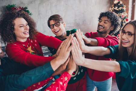 Photo of nice young people team employees highfive teambuilding enjoy cozy christmas decoration interior office indoors corporate partyの写真素材