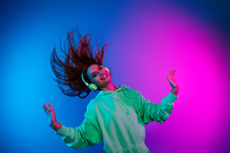 Photo of dreamy lovely girl wear green hoodie headphones having fun empty space isolated pink light color backgroundの写真素材