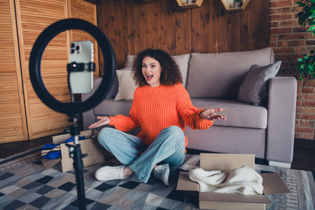 Full length portrait of nice young girl phone holder record video clothes boxes modern loft interior flat indoorsの写真素材
