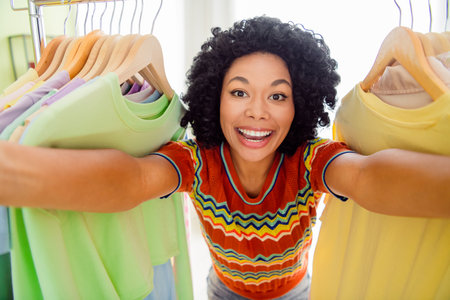 Portrait of pretty young girl take selfie clothes rack wear t-shirt free time modern interior flat indoorsの写真素材
