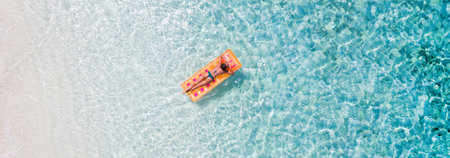 Top above high angle aerial drone view of her she fit slim sporty attractive girl floating lying on rubber mattress clean seaview water enjoy joy peaceful tranquil relax spa recreationの写真素材