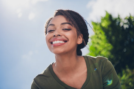 Smiling young woman enjoying a sunny day outdoors, radiating joy and positivity