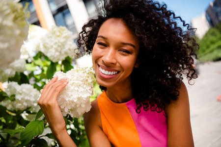 Photo of attractive young cheerful lady touch flowers smile wear colorful garment spend time enjoy...