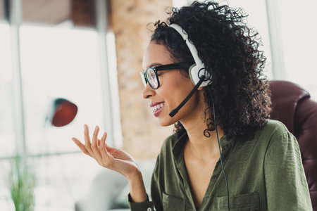 Young professional woman with headset working in a bright office environment, smiling during a...