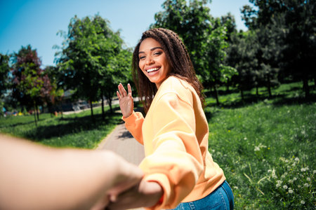 Photo of positive good mood woman dressed orange pullover walking waving hi asking follow her...