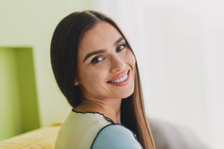Smiling Young Woman Relaxing Indoors in a Bright Home Setting During Daylight Hours