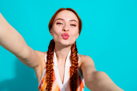 Photo of pretty young girl make selfie kiss wear dress isolated on teal color background