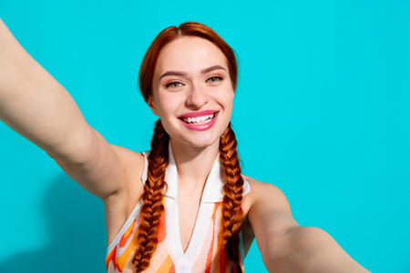 Photo of pretty young girl take selfie wear dress isolated on teal color backgroundの写真素材