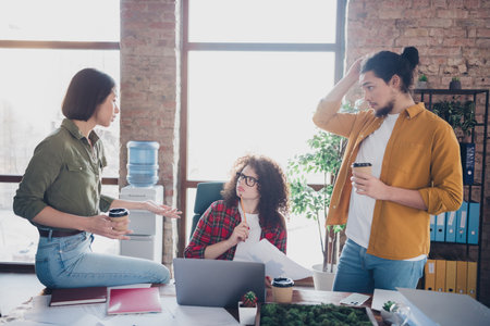 Young professionals discussing project ideas in a casual office environment, collaborating effectively as a diverse teamの写真素材
