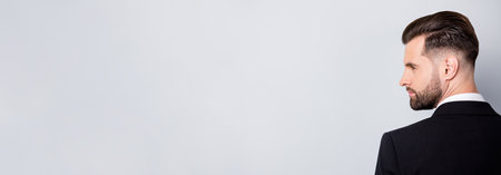 Back rear spine profile side photo of stylish worker man look copyspace listen to his collar wear black classy suit isolated over grey color backgroundの写真素材