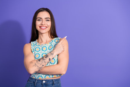 Young woman in casual colorful attire posing confidently against a purple background showcasing style and charmの写真素材