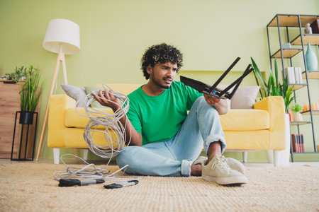 Full size photo of nice young man hold wifi router cable weekend green interior apartment indoorsの写真素材