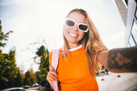 Cheerful young woman in casual outfit enjoying a sunny day outdoors