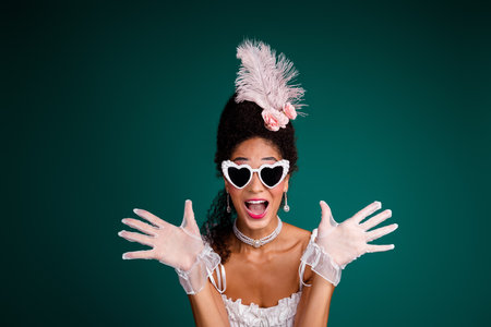 Joyful woman in vintage costume with glamorous accessories and feathered headdress