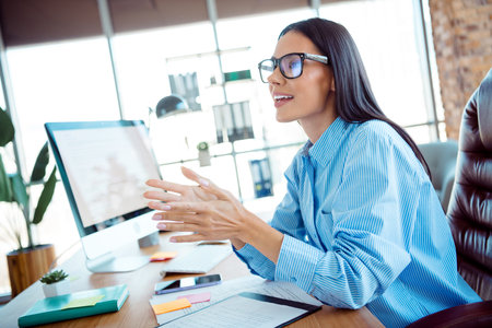 Businesswoman Engaged in an Active Discussion at a Modern Workplace With a Computer