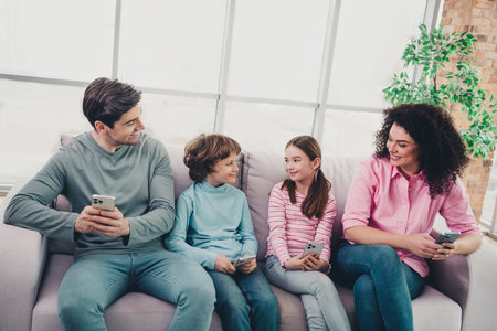 Happy family bonding at home, sitting on a cozy sofa, enjoying time together in a bright interior,...