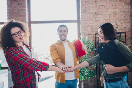 Group of cheerful diverse young professionals collaborating together in a creative office setting during daylight hoursの写真素材
