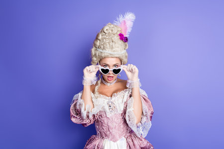 Elegant woman in historic costume with heart-shaped glasses on violet background