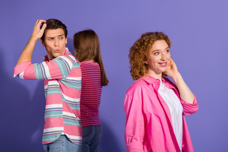 Three cheerful young friends in vibrant casual attire posing joyfully in front of a violet...