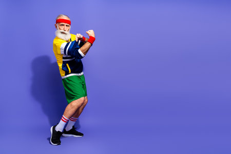 Funny man in retro activewear showing off strength and embracing fitness with vibrant energy against...
