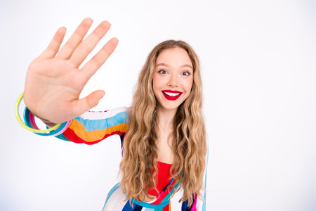 Young woman with vibrant style showing playful gesture in a bright and colorful outfit, embodying...