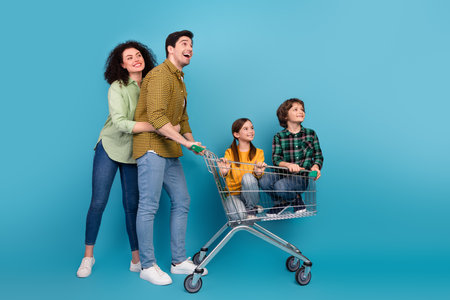 Happy family enjoying time together while shopping and bonding, posing in casual outfits against a vibrant blue backgroundの写真素材
