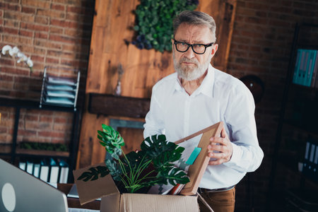 Photo of handsome mature man fired carton box wear white shirt formalwear modern office room interior indoors workspaceの写真素材