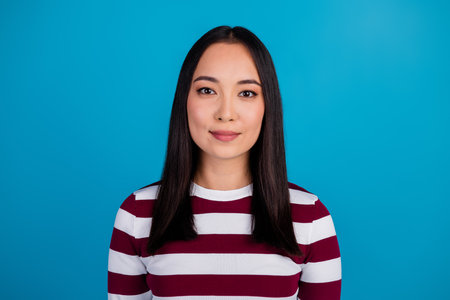 Portrait of stylish young woman wearing a striped shirt with blue background