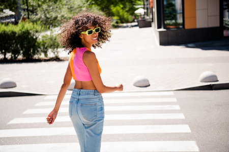 Photo of pretty young woman turn around cross road wear colorful clothes walk outside urban recreation city parkの写真素材