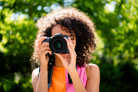 Photo of attractive young cheerful lady photographer take photos you wear colorful garment spend time enjoy weekend outside outdoorsの写真素材
